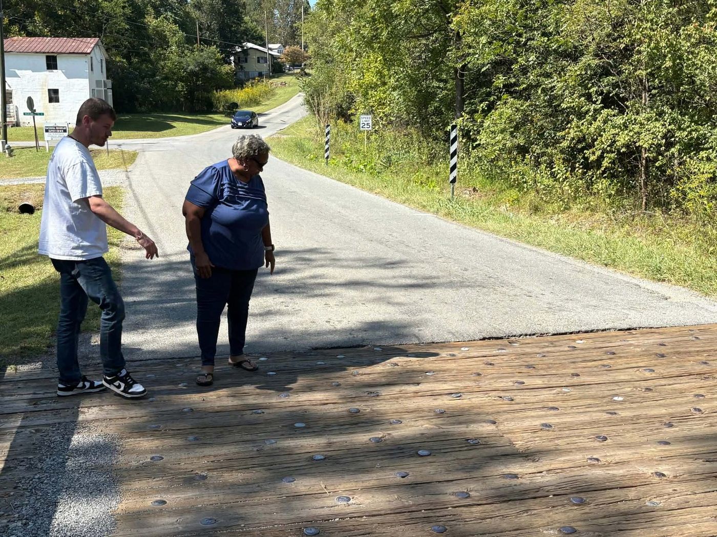 Sandra Smith steps onto the wooden deck of the Diamond Avenue bridge beside Mayor Holland Perdue.
